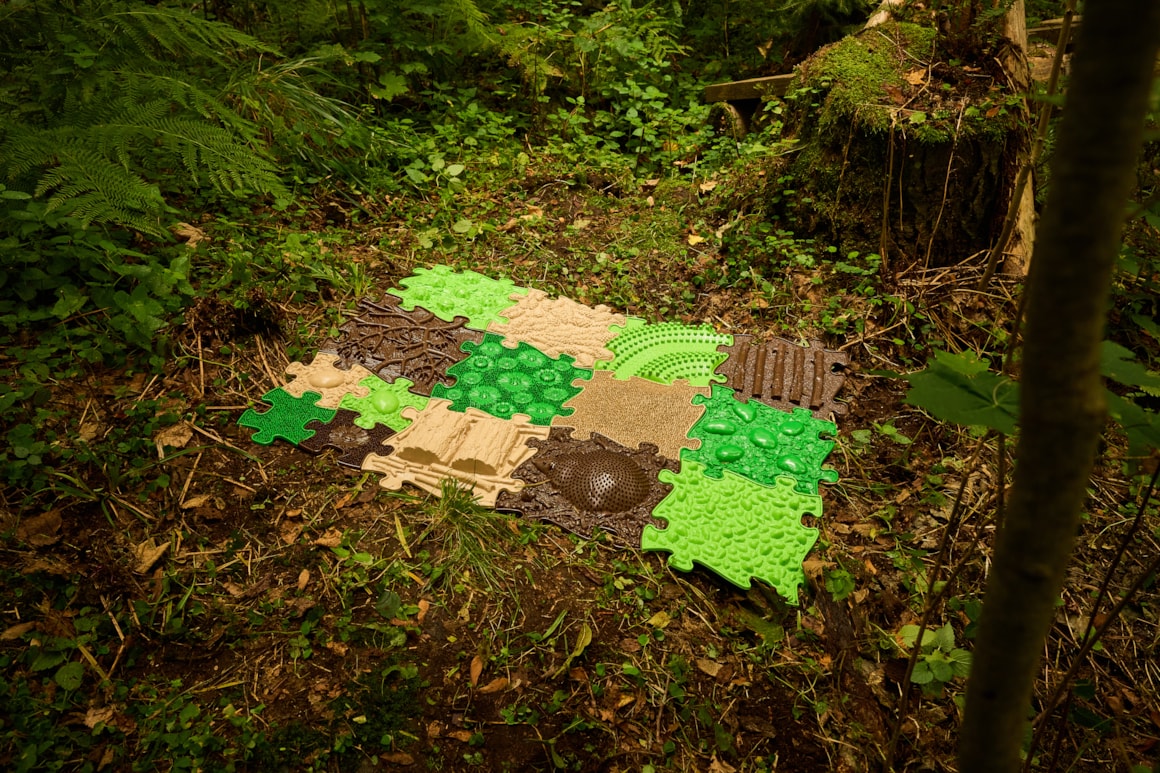 Die Muffik Puzzlematten Natur ist inspiriert von natürlichen Oberflächen aus Wäldern und Wiesen. Jede Matte hat eine einzigartige Textur, die natürliche Oberflächen wie Gras, Wurzeln oder Kieselsteine nachahmt.